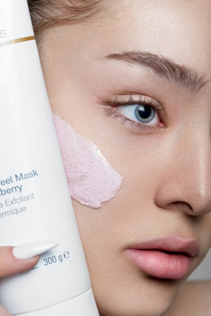 Close-up of a woman applying skincare mask with product visible, showcasing beauty routine.