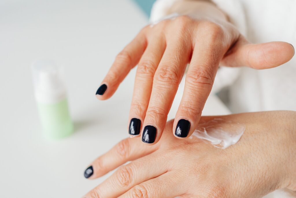 What Causes Dry Skin on Hands? 4 Big Reasons Close-up of a woman applying hand cream for moisturizing.