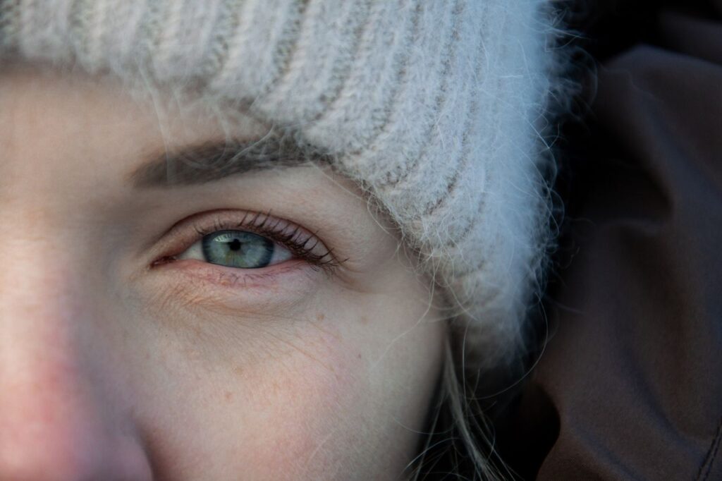 pexels photo 36123489 36123489 1 Close-up of a woman's eye framed by a cozy winter hat, capturing subtle details.