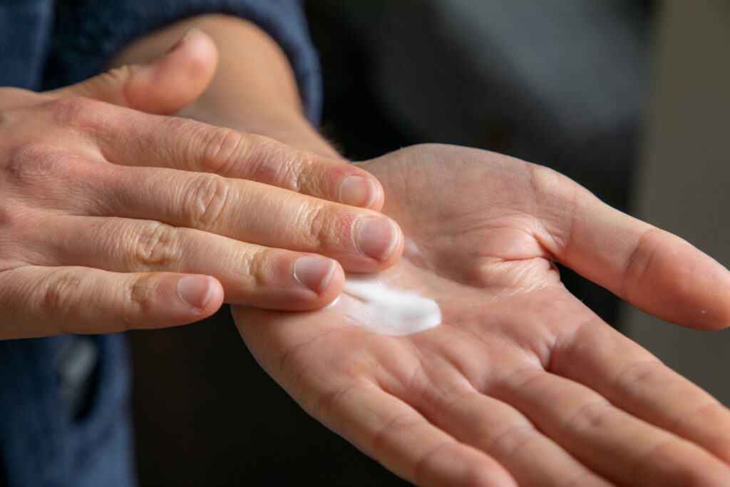 Detailed view of hands applying cream for skincare use.