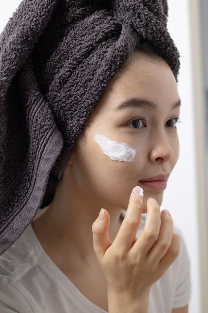 pexels photo 6925495 6925495 Close-up of a woman applying face cream, emphasizing skincare routine and self-care habits.
