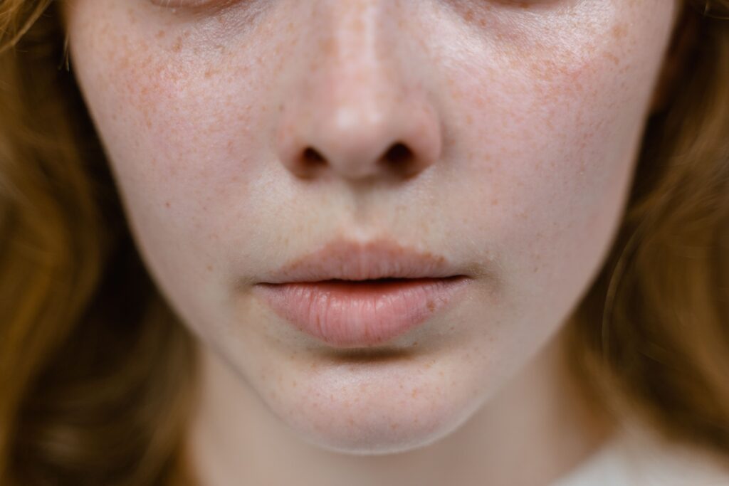 Detailed close-up of a freckled female face focusing on natural features and textures.